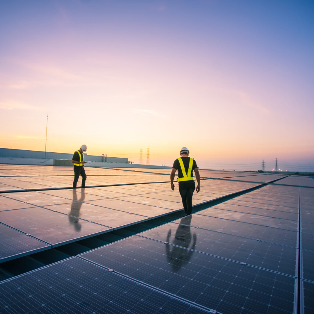 Bauarbeiter auf einem Dach mit Photovoltaikanlage